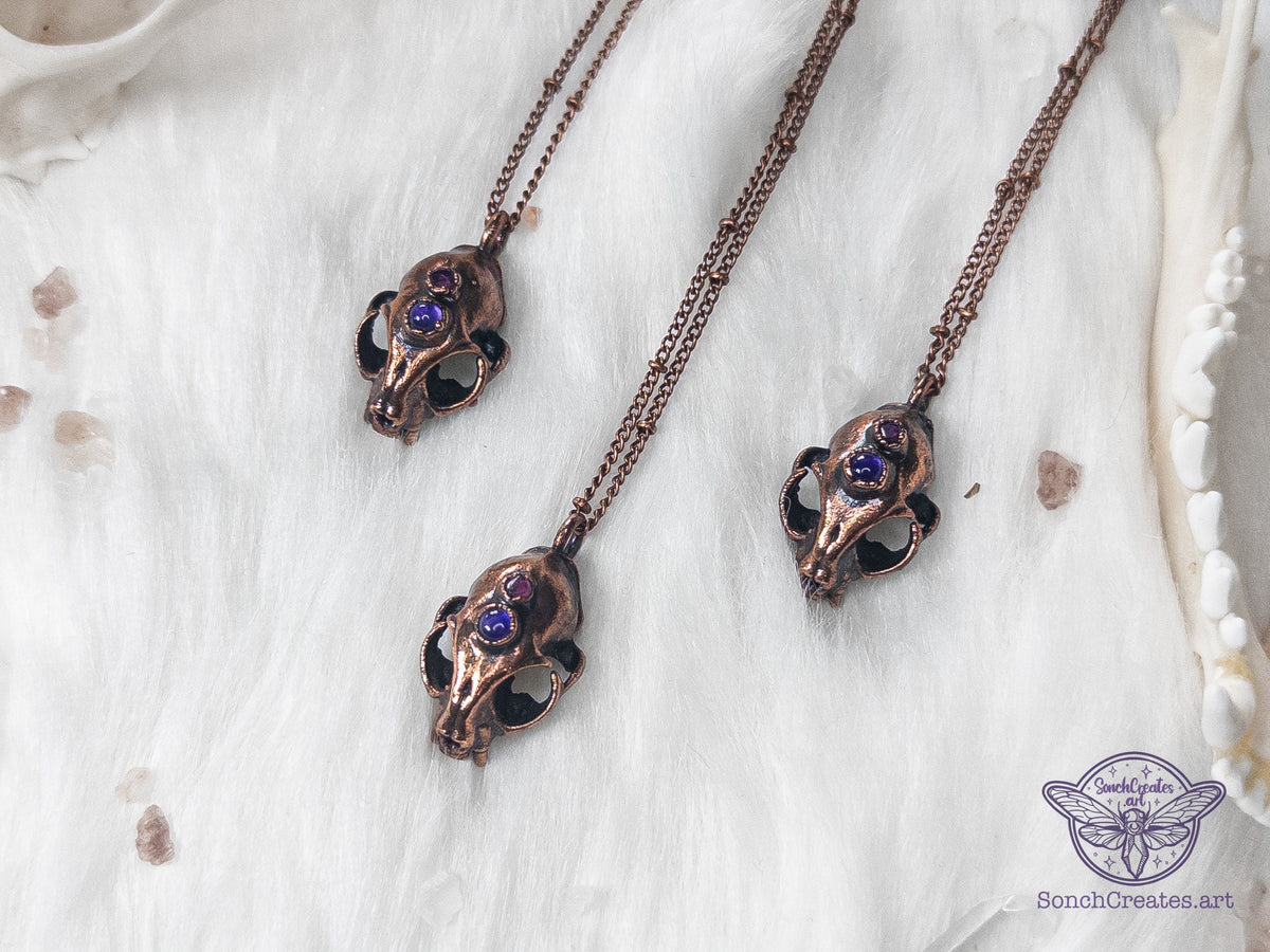 Miniature copper cat skull pendant with amethyst and garnet