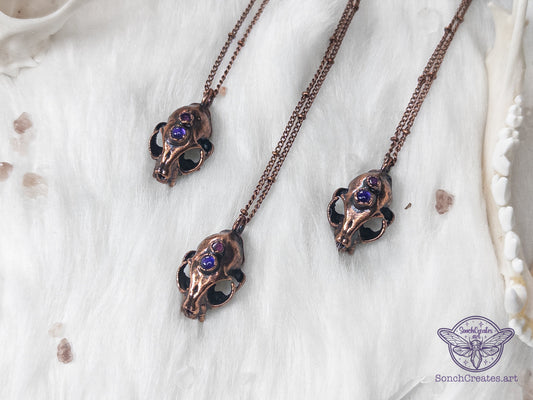 Miniature copper cat skull pendant with amethyst and garnet