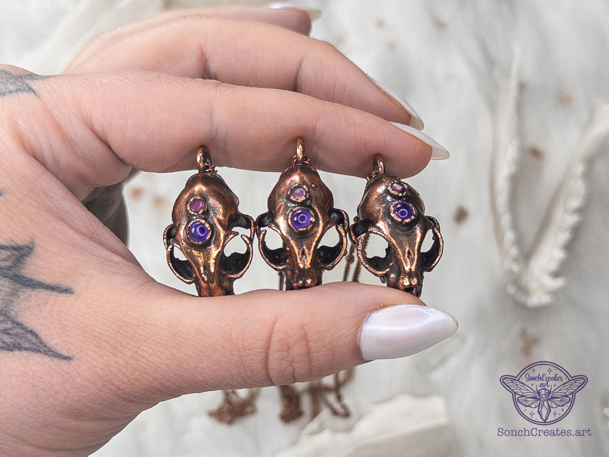 Copper cat skull pendant featuring purple amethyst and red garnet